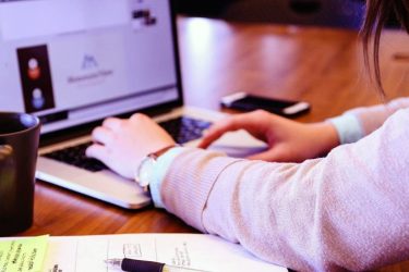 Close up of hands operating a laptop computer