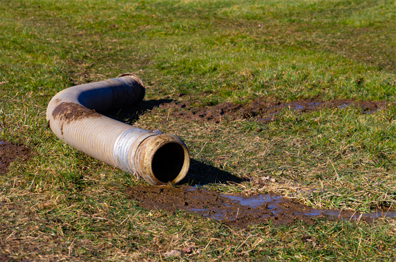 Big pipe with slurry, lying on grass